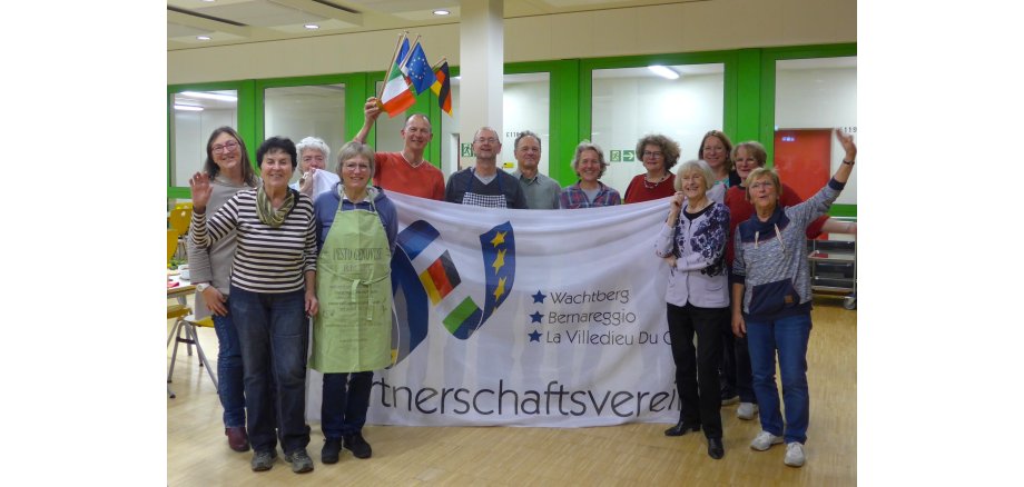 Teilnehmer des französischen Kochabends mit Parnerschaftsfahne