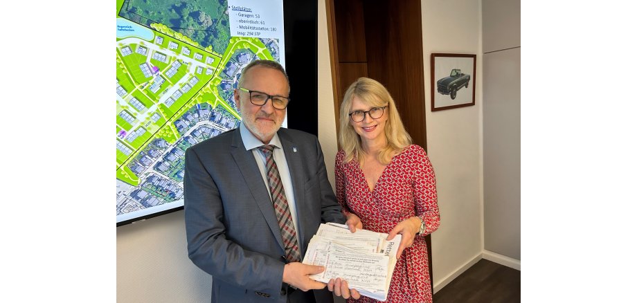 Petra Vieten überreicht Bürgermeister Jörg Schmidt „fast 2000 Unterschriften“. 
